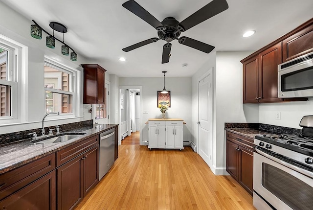 72 Marlboro St, Dedham, MA 02026 - kitchen with stainless steel appliances, a ceiling fan, light wood finished floors, dark stone counters, and hanging light fixtures