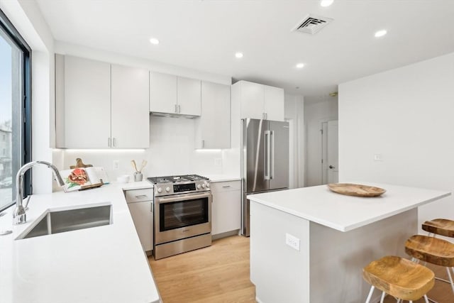 236-256 Dorchester St Unit 201, Boston, MA 02127 - kitchen with stainless steel appliances, a breakfast bar area, recessed lighting, light wood finished floors, and light countertops