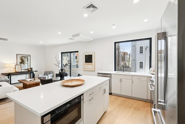 236-256 Dorchester St Unit 201, Boston, MA 02127 - kitchen featuring stainless steel appliances, light countertops, a kitchen island, white cabinets, and recessed lighting
