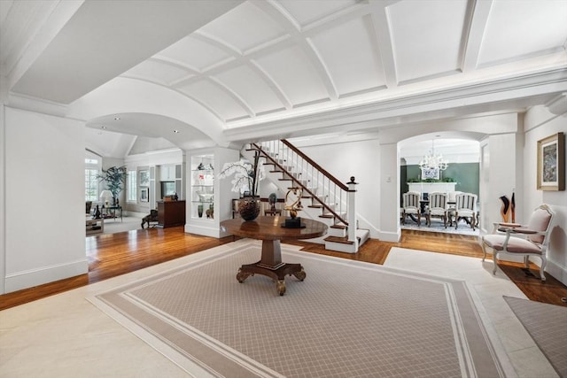 135 Marsh St, Belmont, MA 02478 - interior space featuring arched walkways, vaulted ceiling, wood finished floors, an inviting chandelier, and stairs