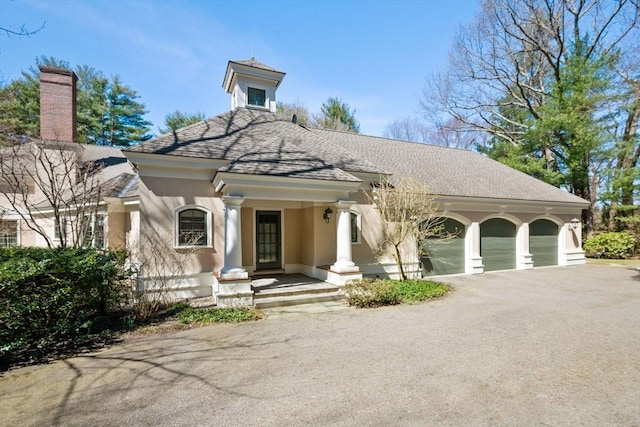 135 Marsh St, Belmont, MA 02478 - view of front of house with an attached garage, aphalt driveway, a shingled roof, and stucco siding