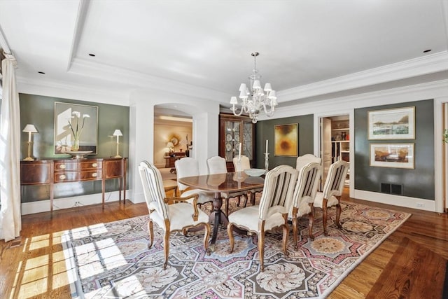 135 Marsh St, Belmont, MA 02478 - dining room with crown molding, arched walkways, wood finished floors, and a notable chandelier