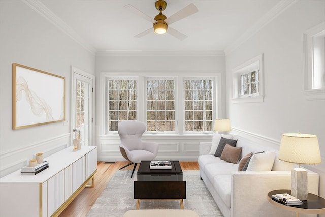 living room with ceiling fan, ornamental molding, and light hardwood / wood-style floors