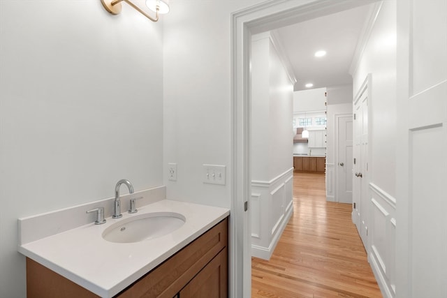 bathroom featuring hardwood / wood-style flooring, vanity, and crown molding