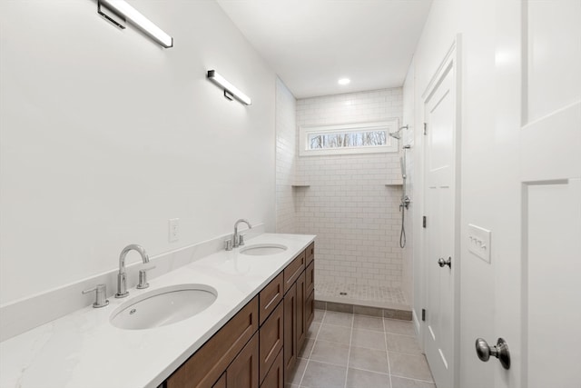 bathroom with vanity, a tile shower, and tile patterned floors