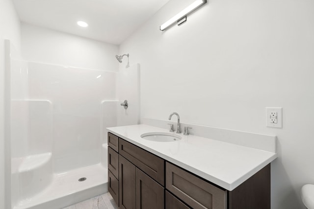 bathroom with walk in shower, vanity, and toilet