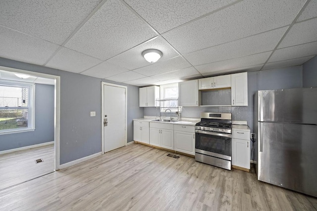 48 Rocliffe St, Fall River, MA 02723 - kitchen with appliances with stainless steel finishes, a sink, a paneled ceiling, white cabinets, and baseboards