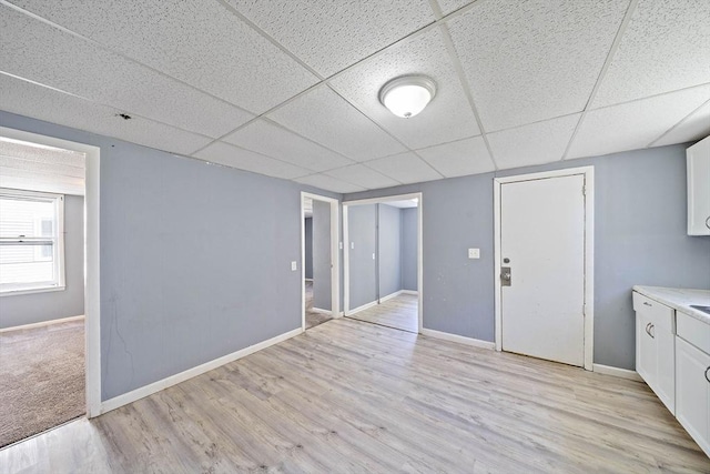 48 Rocliffe St, Fall River, MA 02723 - below grade area with a drop ceiling, light wood-style flooring, and baseboards