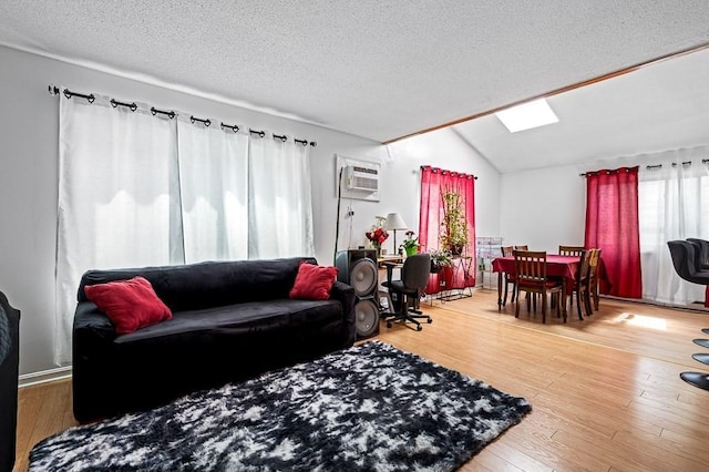 98 Eastern Ave Unit 403, Worcester, MA 01605 - living area with an AC wall unit, vaulted ceiling, healthy amount of natural light, a textured ceiling, and wood finished floors