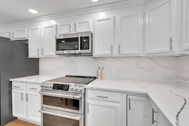 47 Fenwick Cir, Methuen, MA 01844 - kitchen with stainless steel appliances, white cabinetry, tasteful backsplash, light stone countertops, and recessed lighting