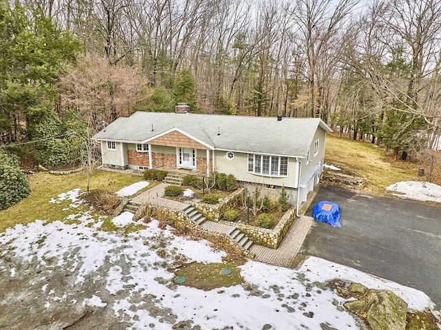 view of front of home with aphalt driveway and a chimney