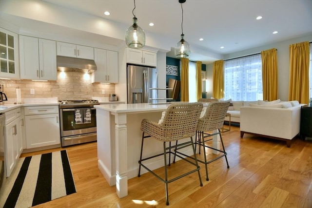 kitchen featuring under cabinet range hood, white cabinetry, appliances with stainless steel finishes, and light countertops