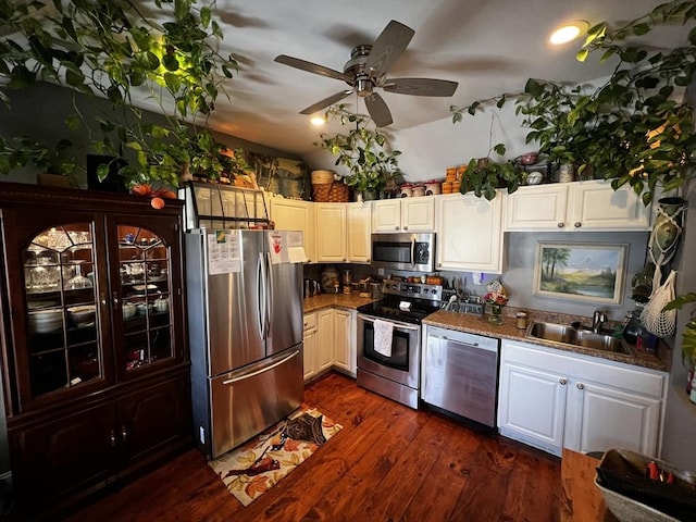 kitchen with dark wood finished floors, white cabinets, stainless steel appliances, a ceiling fan, and a sink