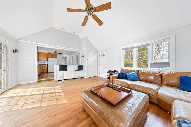 living room with light wood finished floors, a ceiling fan, and vaulted ceiling