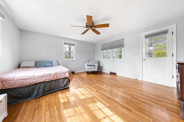 bedroom with light wood finished floors, visible vents, ceiling fan, and baseboards