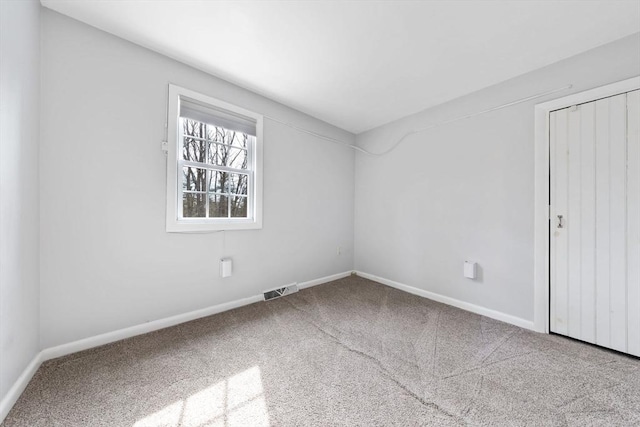 spare room featuring visible vents, carpet flooring, and baseboards