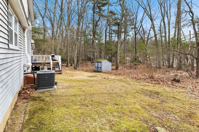 view of yard featuring an outbuilding, a shed, central AC unit, and a wooden deck