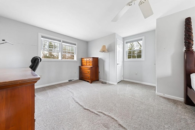 home office featuring visible vents, light colored carpet, a ceiling fan, and baseboards