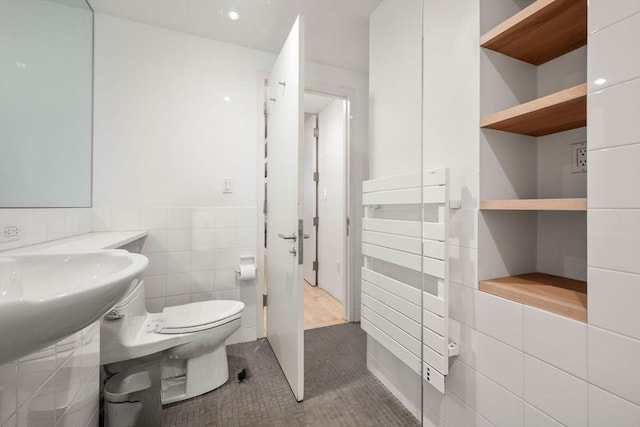 175 Commonwealth Ave Unit A, Boston, MA 02116 - half bathroom featuring tile walls, toilet, a wainscoted wall, and tile patterned floors