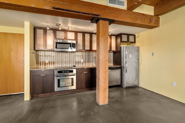 kitchen with light stone countertops, appliances with stainless steel finishes, backsplash, dark brown cabinetry, and beamed ceiling