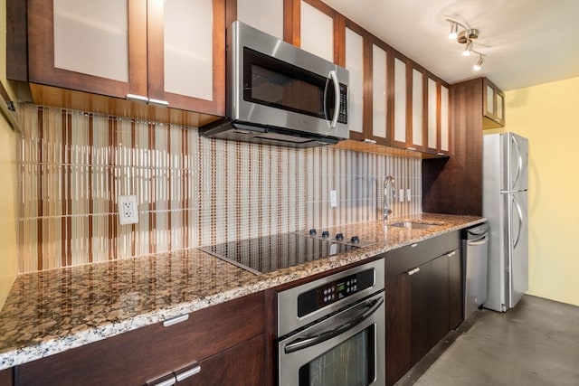 kitchen with backsplash, light stone counters, sink, and stainless steel appliances