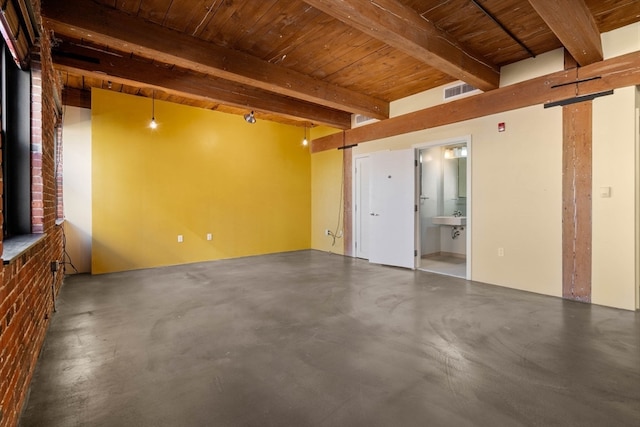 unfurnished room featuring beamed ceiling, concrete flooring, and wood ceiling