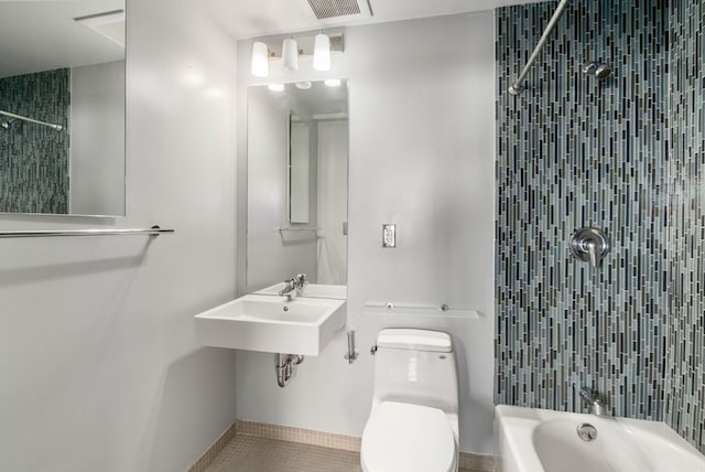 full bathroom featuring tile patterned flooring, sink, tiled shower / bath, and toilet