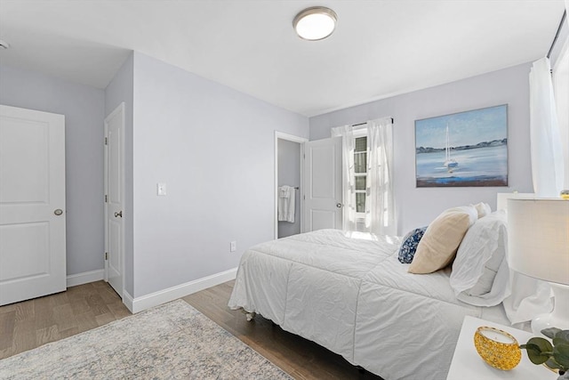 bedroom featuring wood finished floors and baseboards