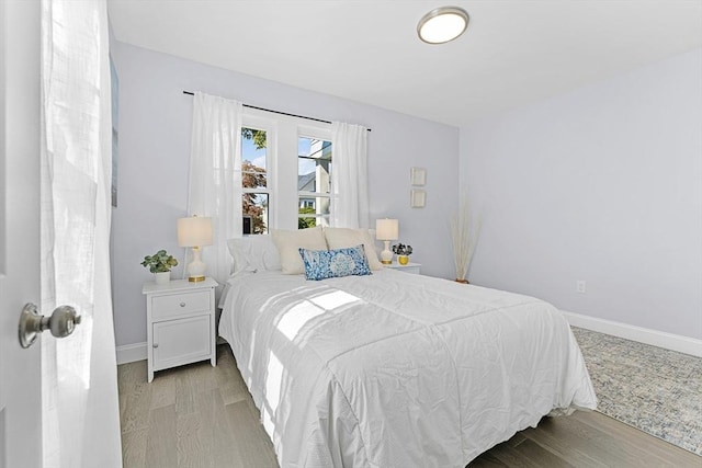 bedroom featuring baseboards and light wood finished floors