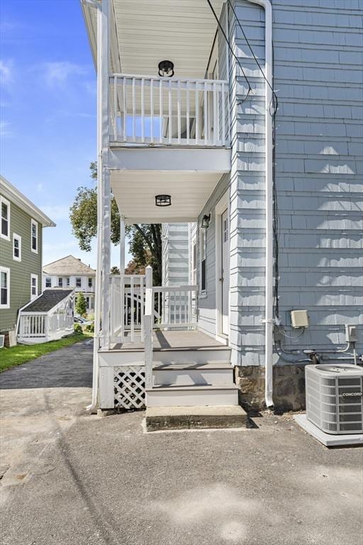 entrance to property featuring central air condition unit and a balcony