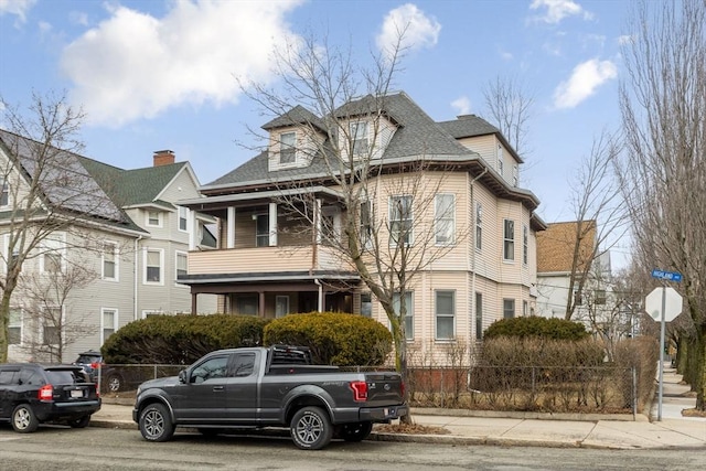 view of front of home featuring roof with shingles and fence