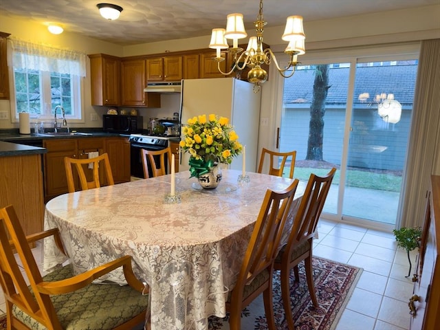 tiled dining area with sink and an inviting chandelier