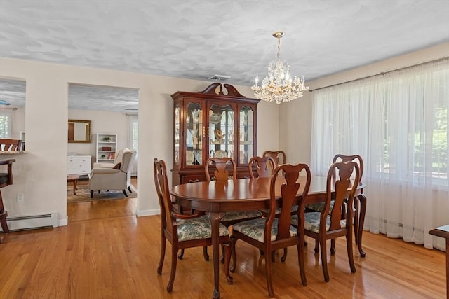 171 Taft Rd, Wilmington, MA 01887 - dining space featuring a baseboard heating unit, a chandelier, plenty of natural light, and light wood-style floors