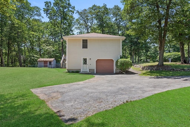 171 Taft Rd, Wilmington, MA 01887 - view of side of home featuring driveway, an attached garage, and a lawn