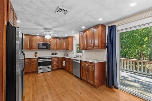 171 Taft Rd, Wilmington, MA 01887 - kitchen with stainless steel appliances, brown cabinetry, light wood-style flooring, a ceiling fan, and recessed lighting