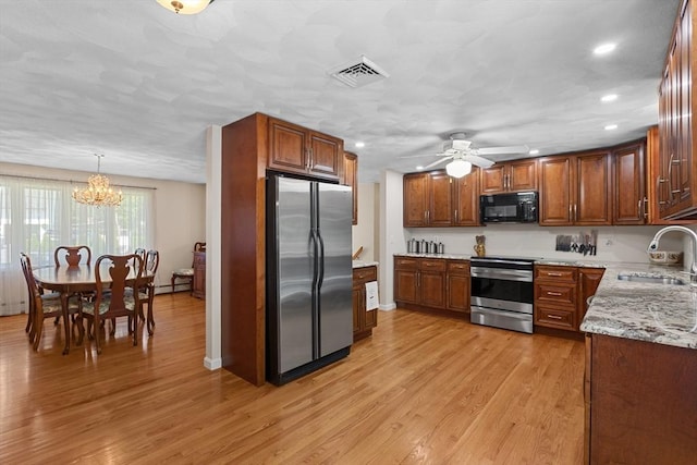 171 Taft Rd, Wilmington, MA 01887 - kitchen with appliances with stainless steel finishes, a chandelier, recessed lighting, light wood-style flooring, and brown cabinets