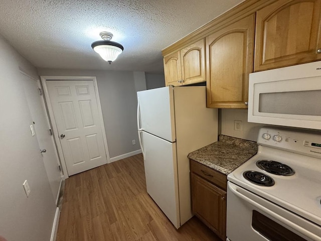 kitchen featuring light wood-type flooring, a textured ceiling, white appliances, and light stone counters