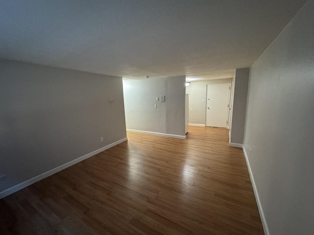 unfurnished room featuring a textured ceiling and dark hardwood / wood-style floors