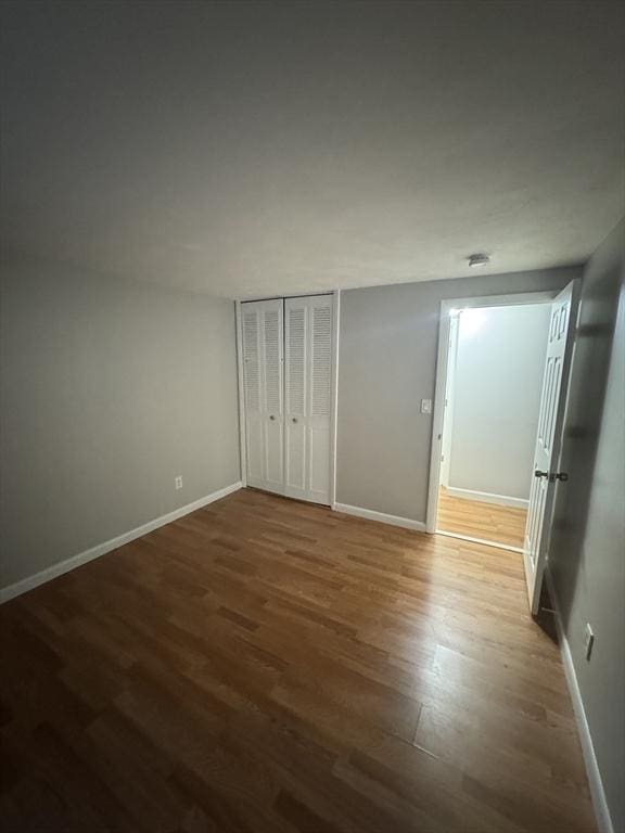 unfurnished bedroom featuring hardwood / wood-style flooring and a closet