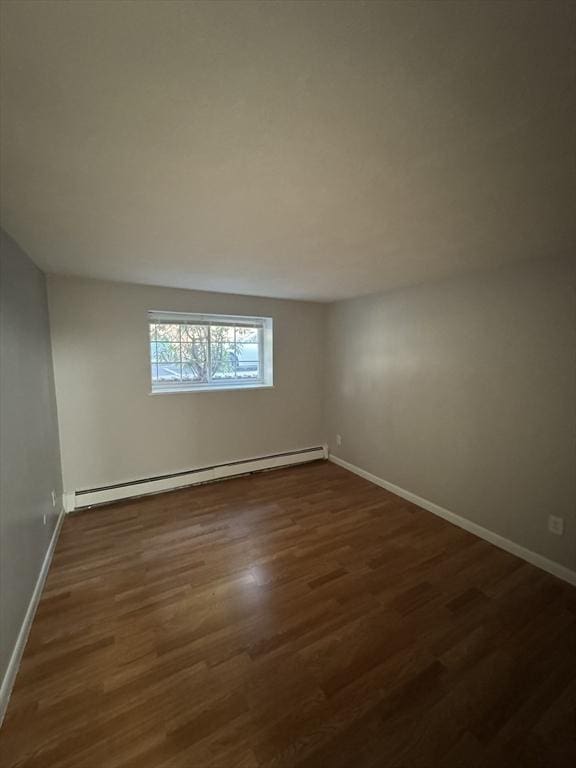 empty room featuring dark hardwood / wood-style flooring and baseboard heating