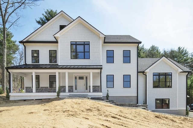 modern farmhouse style home featuring a standing seam roof, metal roof, and covered porch