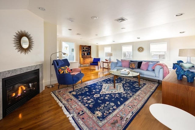 living room with a fireplace, hardwood / wood-style flooring, and lofted ceiling