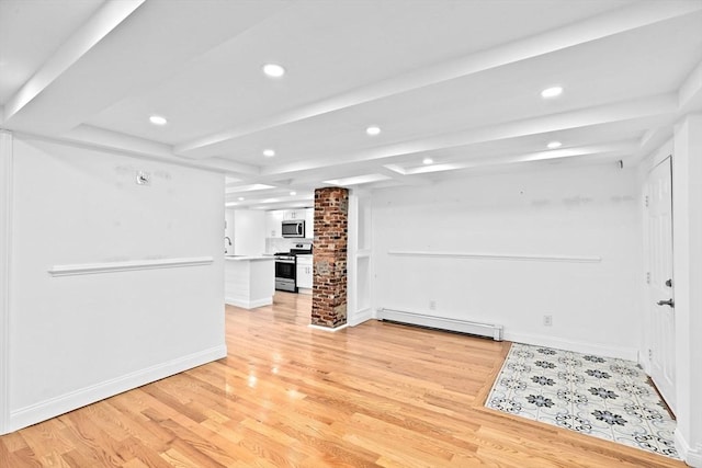 unfurnished living room featuring light wood-type flooring, baseboard heating, and decorative columns