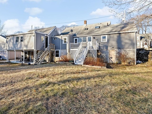 back of house featuring a lawn and a patio