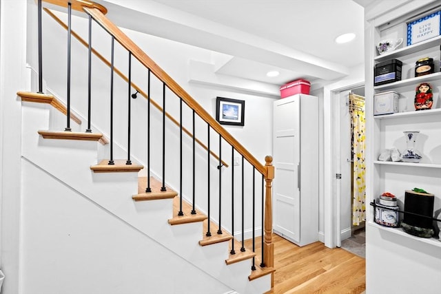 stairway featuring hardwood / wood-style flooring and built in features