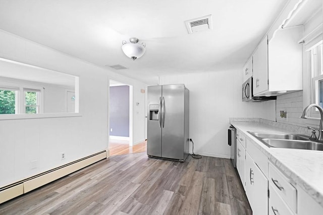 101 Alpha St, Dartmouth, MA 02747 - kitchen featuring stainless steel appliances, a baseboard heating unit, a sink, white cabinetry, and light countertops