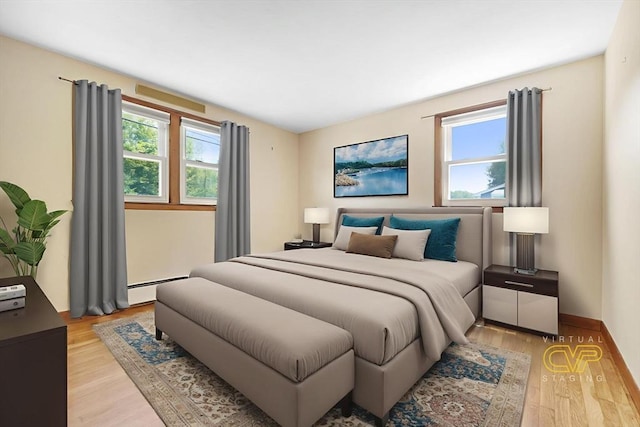 101 Alpha St, Dartmouth, MA 02747 - bedroom featuring multiple windows, light wood finished floors, and a baseboard heating unit