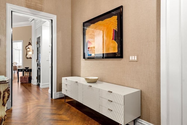 hallway featuring wallpapered walls, crown molding, and baseboards