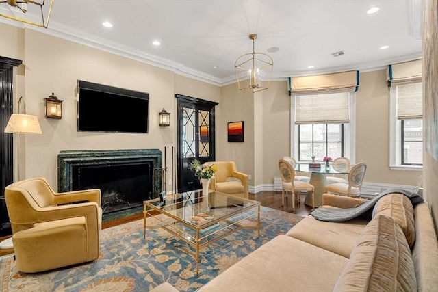 living room with ornamental molding, wood finished floors, recessed lighting, a fireplace, and baseboards