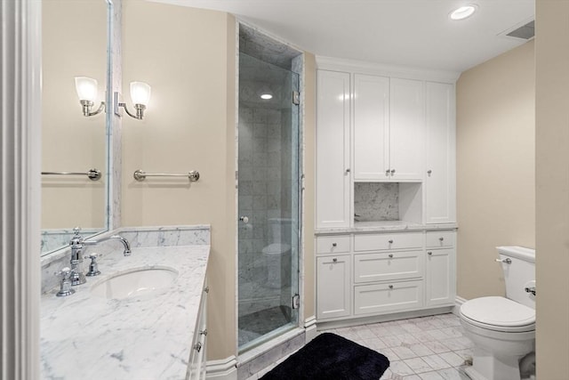 bathroom featuring tile patterned floors, a stall shower, toilet, and vanity